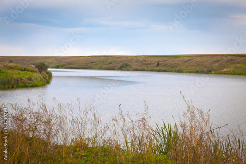 summer landscape with river, sky and surrounding plants