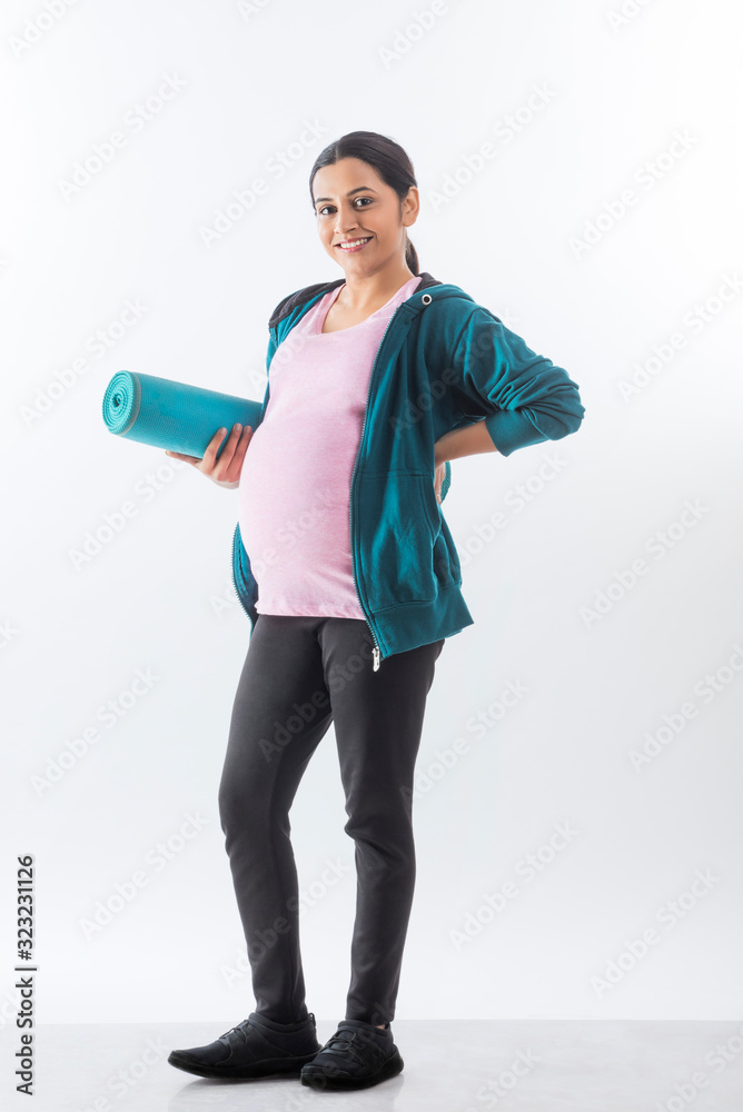 Pregnant woman holding a yoga mat in hand. Pregnant woman holding a yoga mat in hand.