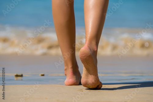 Woman walking on tropical white sand beach. Summer vacation