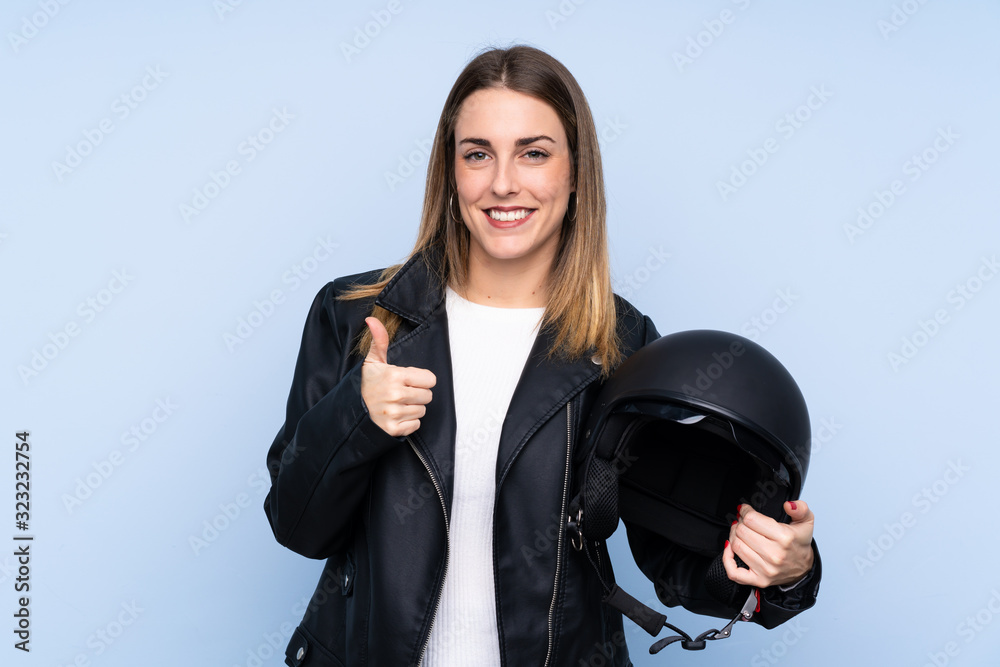 Εκτύπωση καμβά Young blonde woman with a motorcycle helmet over isolated blue background with t