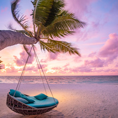 Tropical sunset beach background as summer landscape panorama with beach swing or hammock and white sand and calm sea beach banner. Perfect beach scene vacation or summer holiday concept