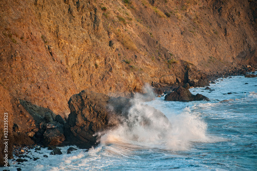 A wave breaking across a rocky shore.