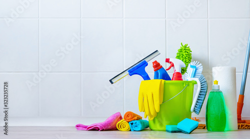 Bucket of cleaning supplies in the front of tiled wall