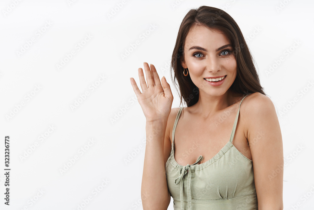 Hello how are you. Informal greeting concept. Charming, silly and coquettish, flirty brunette female waving hand to say hi, smiling seeing familiar person, meet friend, white background Hello how are you. Informal greeting concept. Charming, silly and coquettish, flirty brunette female waving hand to say hi, smiling seeing familiar person, meet friend, white background