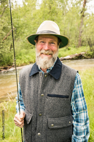 Portrait of bearded fly fishing guide next to stream. Red Lodge, Montana, USA photo