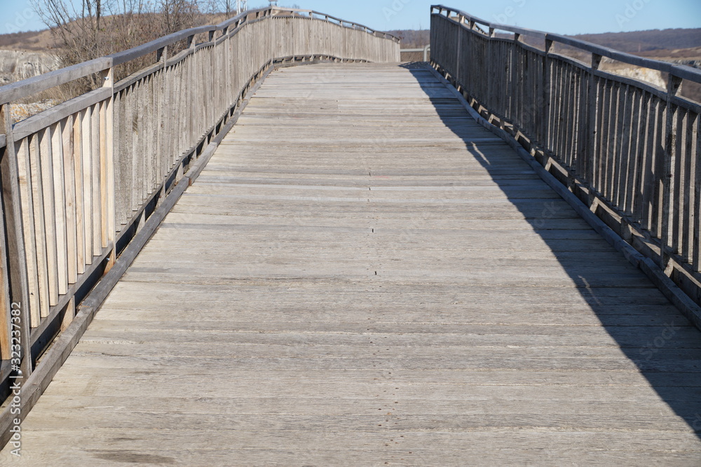 empty wooden bridge with railing on a sunny day