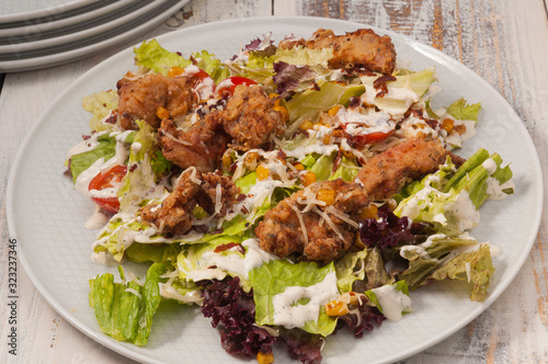 salad with deep-fried chicken, greens, corn and tomatoes