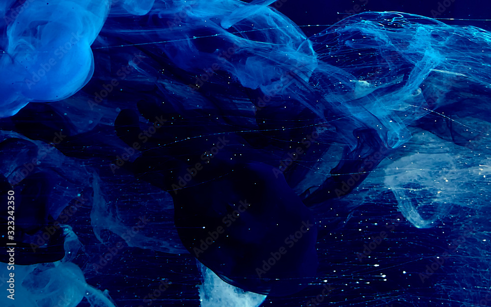 Blue watercolor ink in water on a black background. Colored space magic background. - obrazy, fototapety, plakaty 
