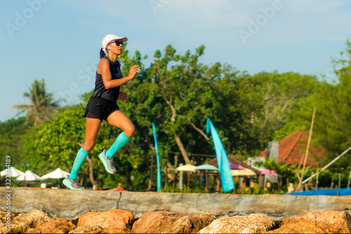fitness lifestyle portrait of young attractive and athletic woman in compression running socks jogging happy on city park doing intervals workout in athlete training concept