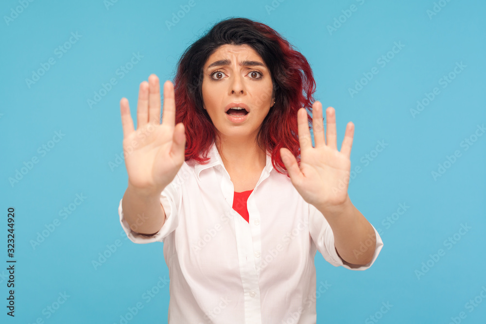No, I'm afraid! Portrait of scared stressed woman with fancy red hair in white shirt gesturing stop and shouting from fear, afraid of sudden threat. indoor studio shot isolated on blue background No, I'm afraid! Portrait of scared stressed woman with fancy red hair in white shirt gesturing stop and shouting from fear, afraid of sudden threat. indoor studio shot isolated on blue background