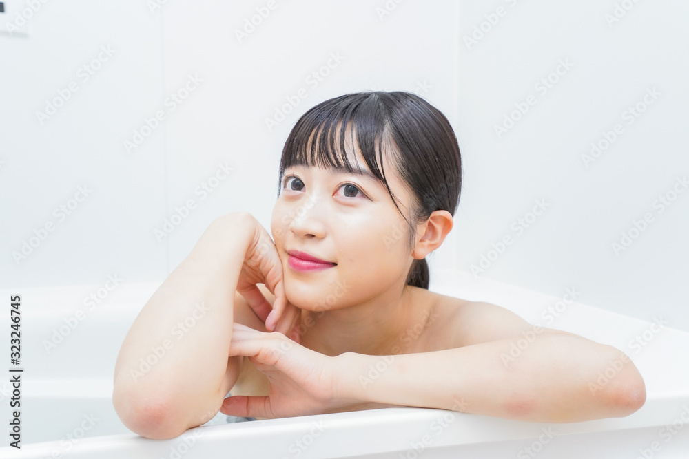 お風呂でお湯に浸かる若い女性