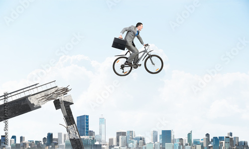 Man on bike jumping from broken bridge © adam121