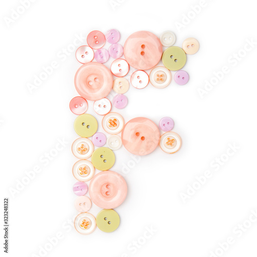 Letter F from pink and green buttons isolated on white background. Sewing kit. Colorful buttons, stylish alphabet for handmaking hobby. Handmade sew abc. Text from buttons