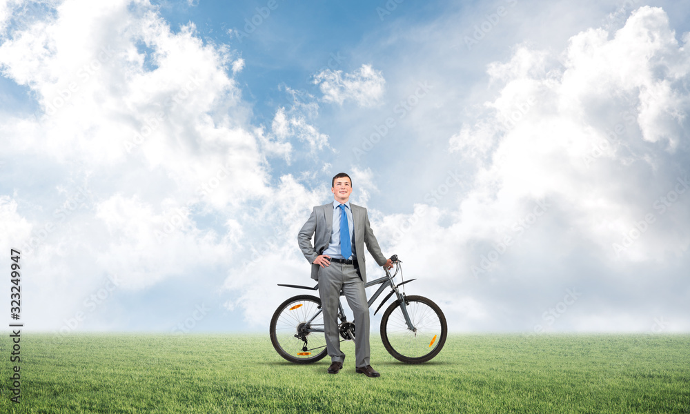 Smiling businessman with bicycle outdoors