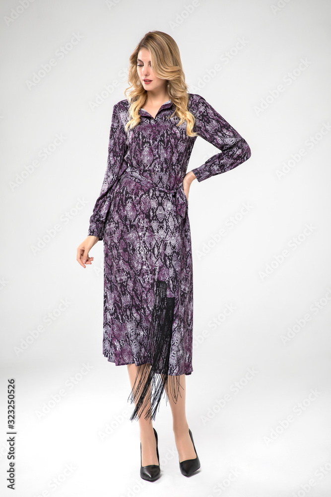 beautiful blonde model posing in long chic purple dress. white background. beautiful blonde model posing in long chic purple dress. white background.