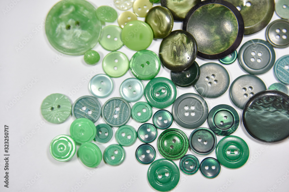 Green buttons of different shape and size on the white background. Selective focus. Green buttons of different shape and size on the white background. Selective focus.