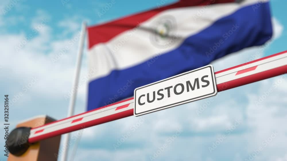 Barrier gate with CUSTOMS sign being closed with flag of Paraguay as a background. Paraguayan Border closure or protective tariffs