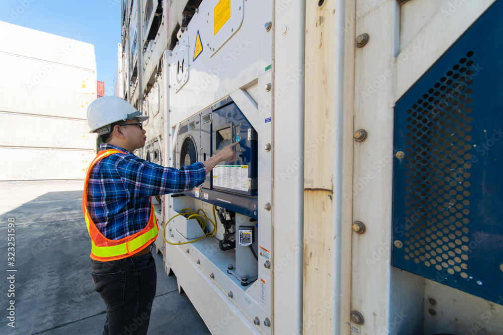 Young man Reefer technician is monitoring reefer container at the container storage Young man Reefer technician is monitoring reefer container at the container storage