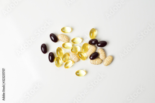 Scattered pills on a white background. Astaxanthin, fish oil and vitamins. Top view.