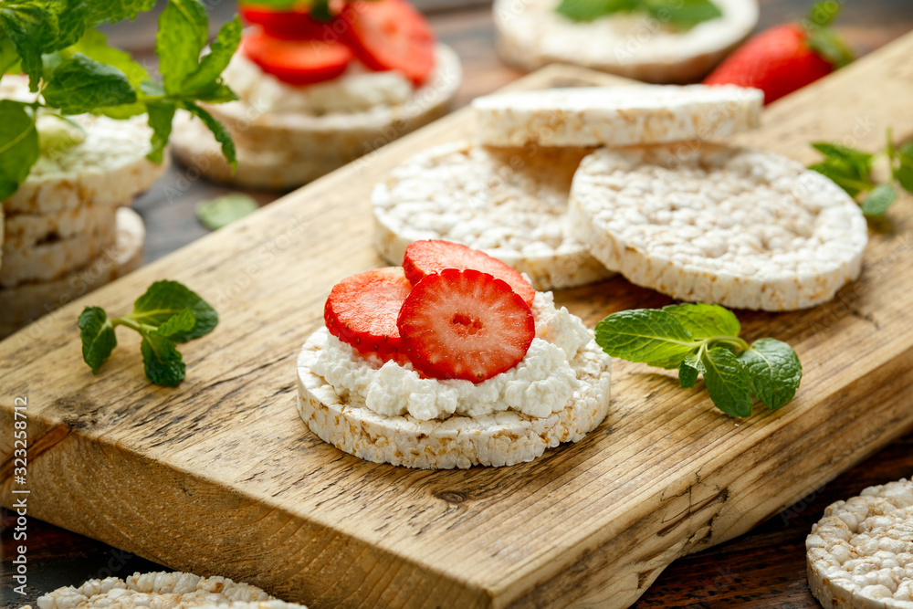Rice crackers with ricotta and strawberries on wooden board. healthy food Rice crackers with ricotta and strawberries on wooden board. healthy food