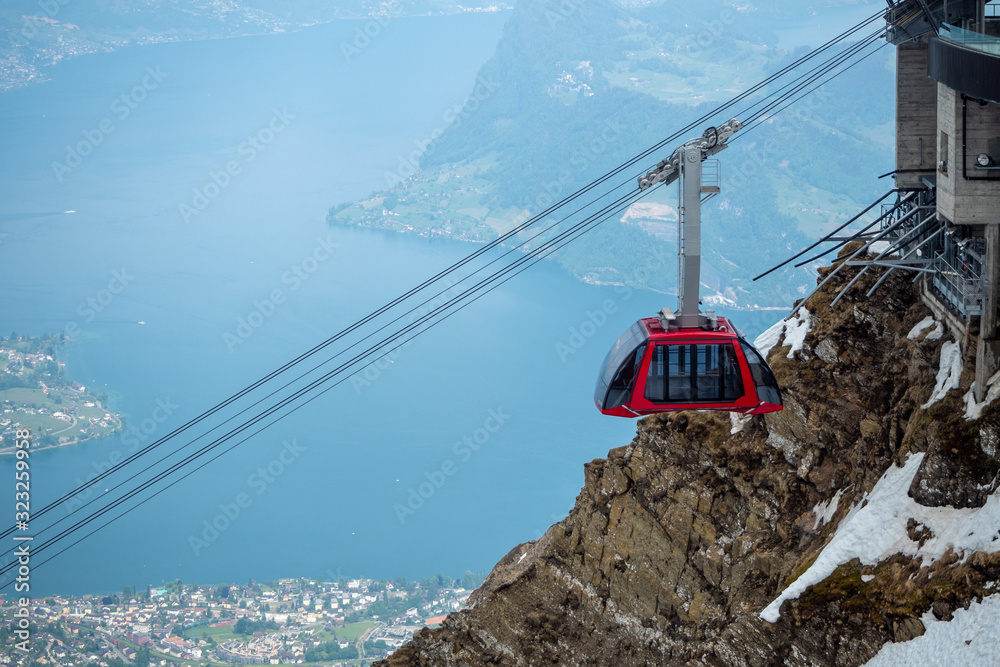 Fototapeta premium Red cable car move in to station at the top of Pilatus mountain with beautiful view background , copy space , Lucerne , Switzerland