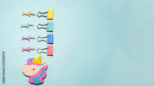 Four binder clips isolated on blue background.