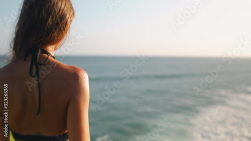 Woman Standing on Rocky Cliff Edge Banawa Beach. Fit Caucasian Girl Contemplating Ocean Waves Crashing Camera Zoom in. Indonesia Vacation. Wild Sumba Island, Tanjung Radar. Footage Shot in 4K photo