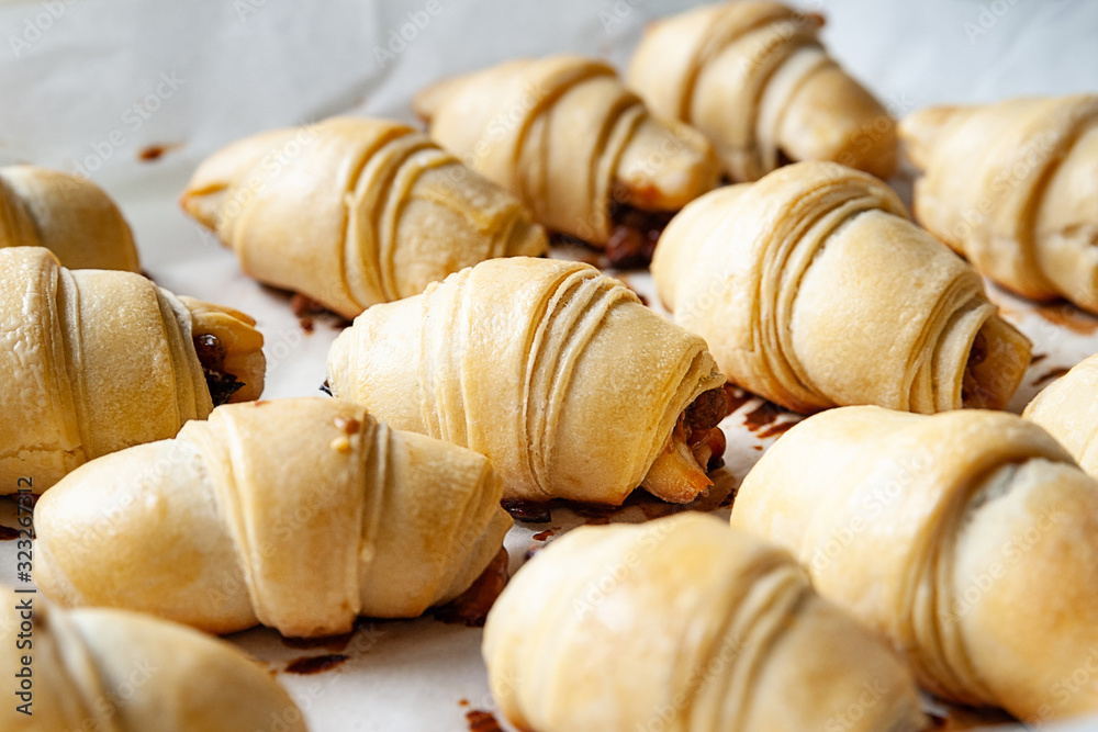 Homemade baking. Sweet rolls with fillings stacked on parchment paper on a baking sheet.