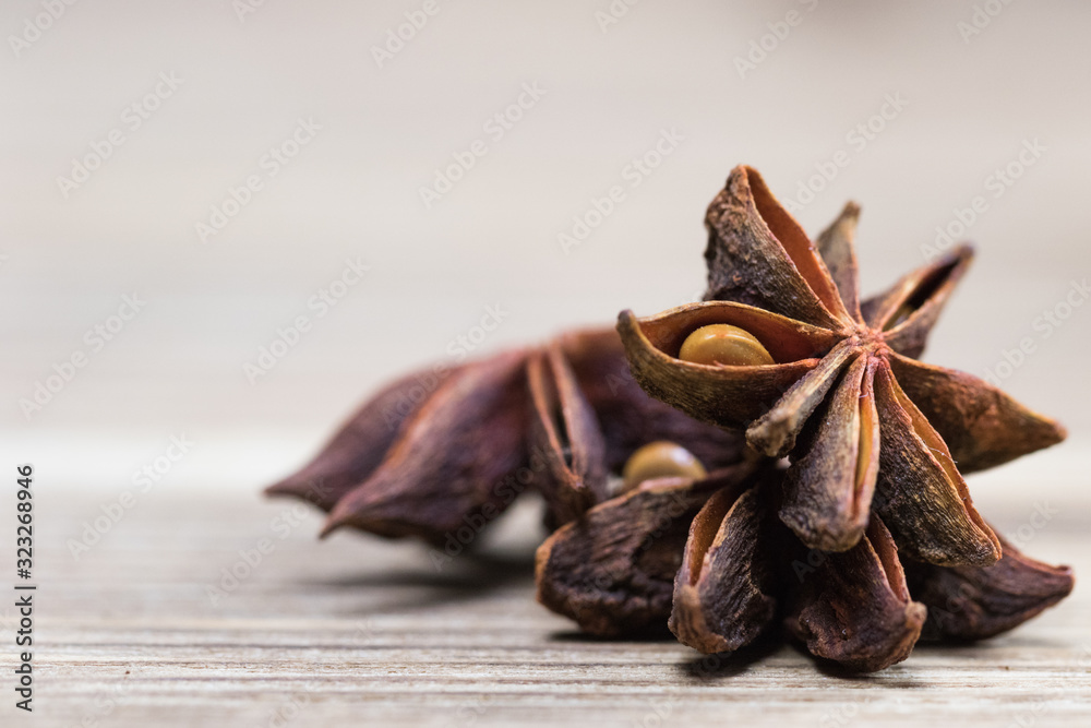 star anise with or without seed, closed, on a light wooden surface. spice for the recipe. beautiful picture, background.