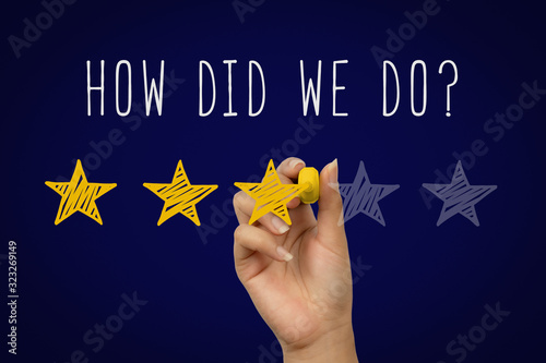 Female hand writing how did we do text with customer satisfaction star rating - Gold doodle stars client experience feedback score - 3 of 5 positive negative review - Business and evaluation concept