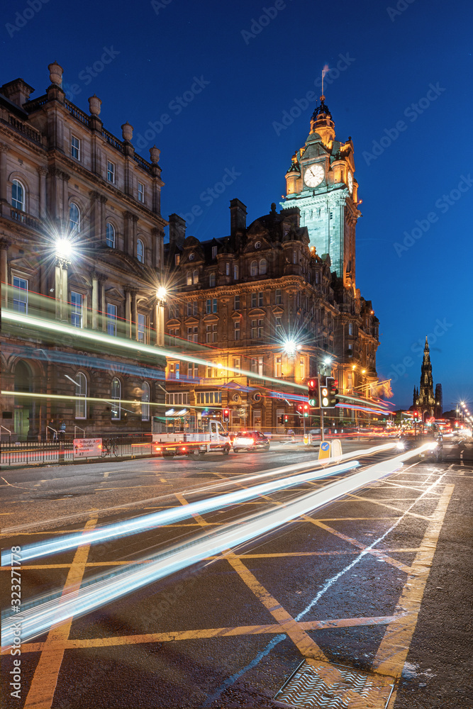 Balmoral's clock tower, Edinburgh, Scotland - January 17, 2014 - Heritage building with movement of car light trail during twilight