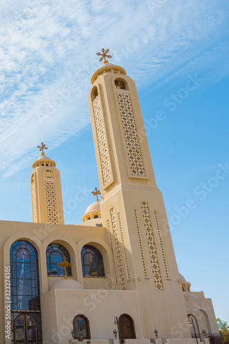 Coptic Orthodox Church in Sharm El Sheikh, Egypt.Against the backdrop of a beautiful sky with clouds. All Saints Church. Concept of the righteous faith. vertical photo