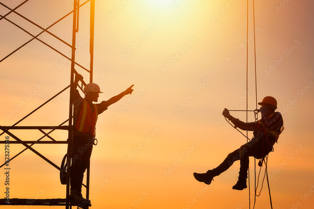 Construction worker wearing safety work at high uniform on scaffolding ...