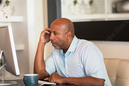 Mature African American man working from his home office. photo