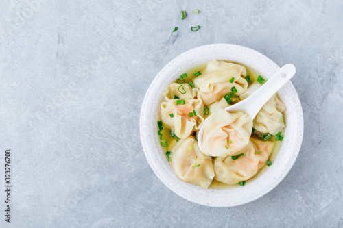 Wonton soup bowl. Shrimp or pork wonton soup with green onion photo