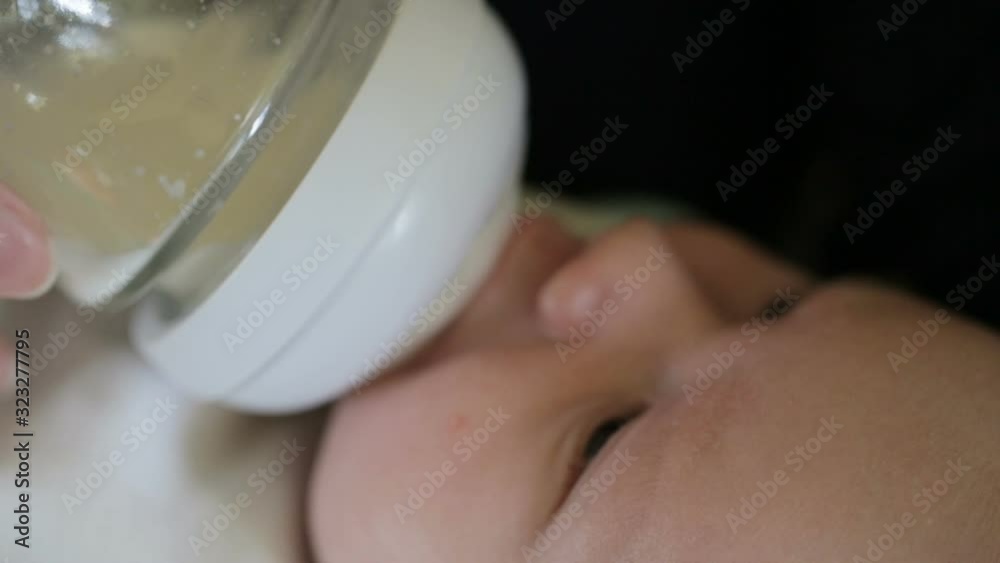 Little infant baby lying on mothers hand drinking milk from bottle. Baby food. Mom and child. Little infant baby lying on mothers hand drinking milk from bottle. Baby food. Mom and child.