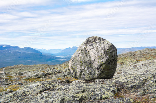 Big stone on the rocks and mountain view on the background, Saana, Enontekio, Kilpisjarvi, Lapland, Finland photo