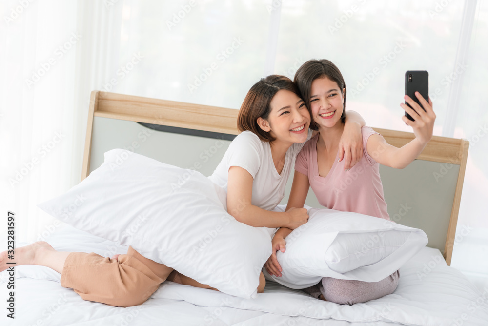 Lesbian couple asia embracing in the bed,Play phone happily Lesbian couple asia embracing in the bed,Play phone happily