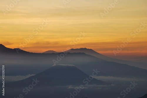 Rinjani Mountain Landscape and Pink sky in the morning with fog and misty around the Valley. View from Bromo Mountain at Bromo tengger semeru national park , Indonesia - nature backdrop