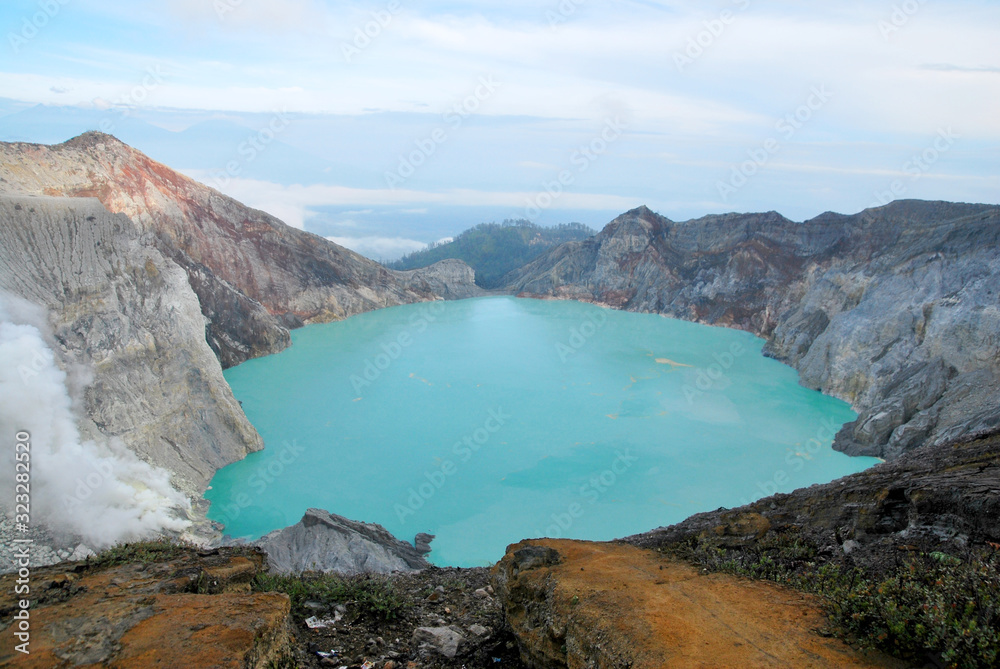 Nature scene of Kawah Ijen volcano and sulfur lake with the tourist man is composite volcanoes in the Banyuwangi Regency of East Java, Indonesia,