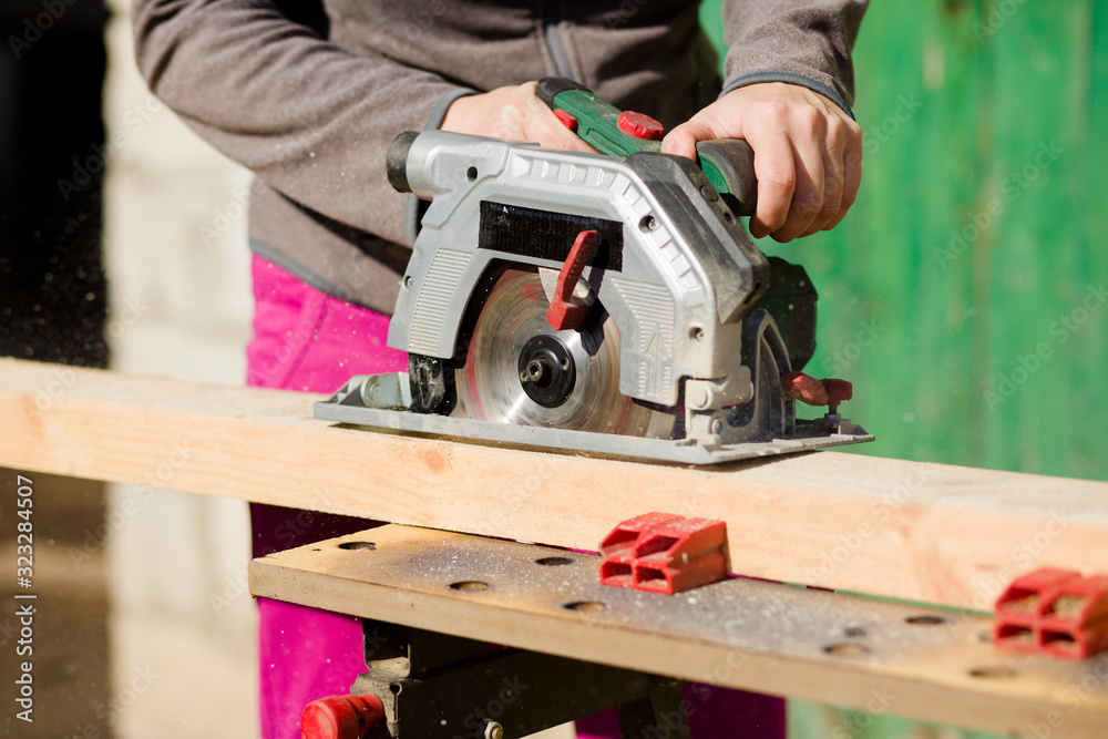 Cutting a standing worker and sawing with a circular saw, industrial construction connecting wooden beams Cutting a standing worker and sawing with a circular saw, industrial construction connecting wooden beams