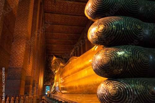 The giant reclining Buddha in Wat Pho in Bangkok with focus on the face. Kingdom of Thailand.