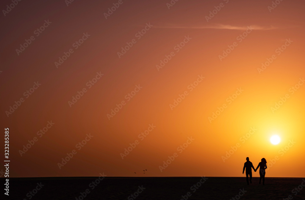 couple on beach at sunset, corralejo, fuerteventura.