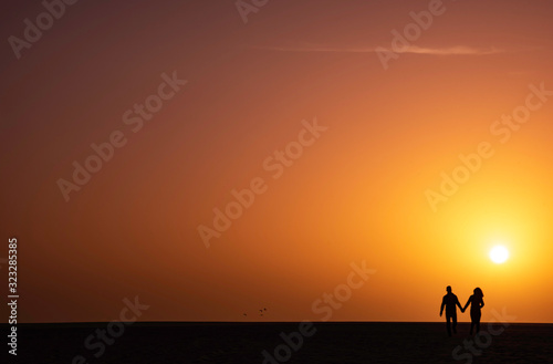 couple on beach at sunset, corralejo, fuerteventura.