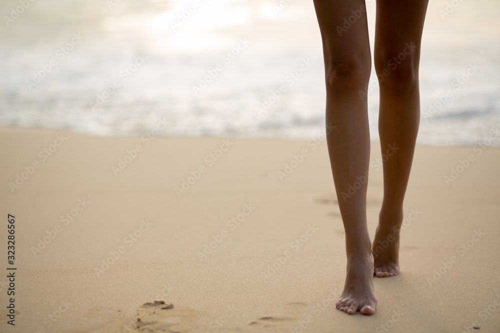 beautiful tanned legs of the girl go next to the sea and footprints in the sand beautiful tanned legs of the girl go next to the sea and footprints in the sand