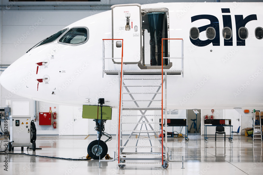 Fototapeta premium Airplane in a white hangar for maintenance