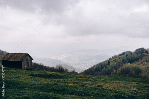House on a mountainside covered with green grass © Ilya.K
