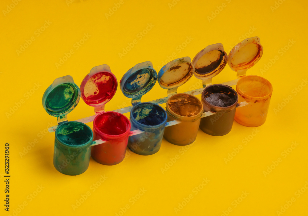 Gouache bottles of paint on a yellow background. Gouache bottles of paint on a yellow background.