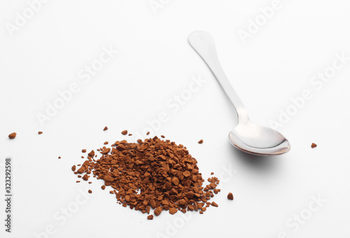 Metal spoon with granulated coffee on a white background