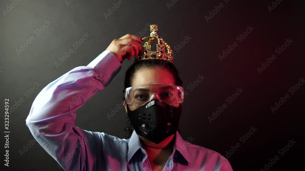 Woman in surgical or medical mask put on the crown on the head, depicting Coronavirus or covid 19, virus outbreak concept. Corona virus disease 2019-nCoV protection and prevention. 4k. Woman in surgical or medical mask put on the crown on the head, depicting Coronavirus or covid 19, virus outbreak concept. Corona virus disease 2019-nCoV protection and prevention. 4k.